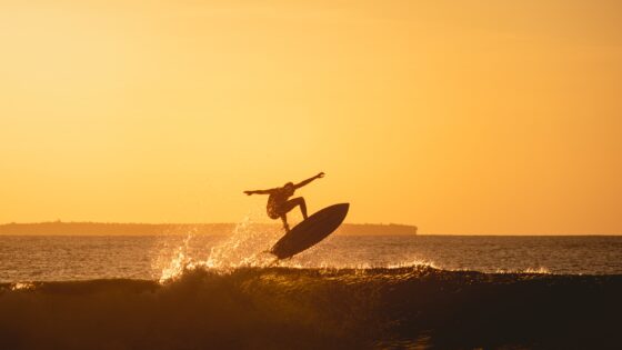 vista hipnotizante da silhueta de um surfista no oceano durante o por do sol na indonesia