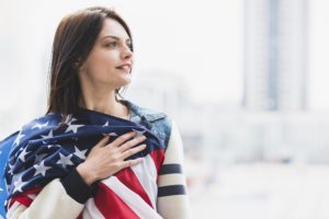 woman pressing down american flag heart