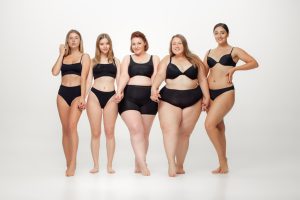 portrait of beautiful young women with different shapes posing on white