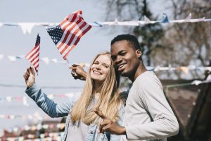 multiethnic man and woman with american flags