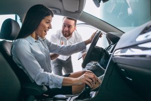 salesman and woman looking for a car in a car showroom