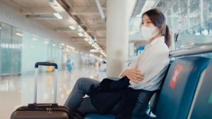 asian business girl with luggage sitting in bench wait and look partner for flight at airport