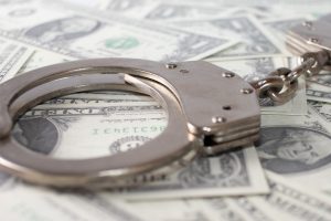 closeup view of metal handcuffs and dollars