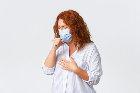 distanciamento social covid 19 auto quarentena de coronavirus e conceito de pessoas mulher ruiva de meia idade doente tossindo usando mascara medica tendo azedume sintomas de doenca gripe