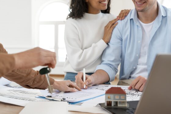 casal sorridente assinando contrato para nova casa