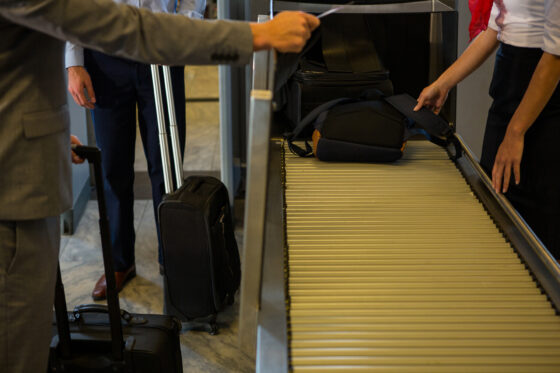 female staff checking passengers luggage conveyor belt