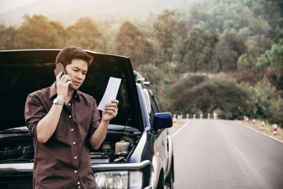 man try fix car engine problem