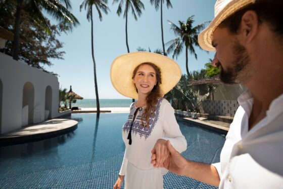 casal caminhando a beira da piscina durante as ferias